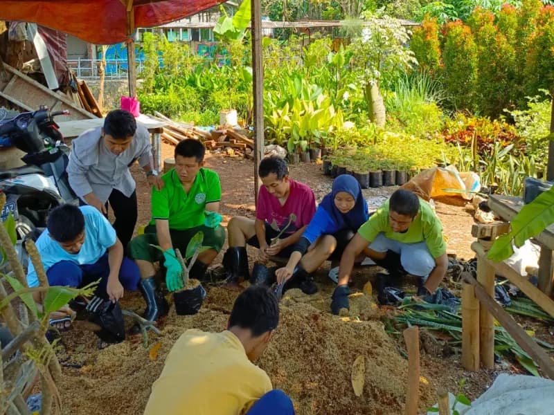 Siswa dan pendamping duduk melingkar mengolah media tanam di lahan pembibitan